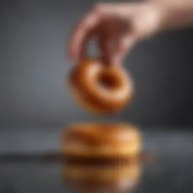 A close-up of a donut being dipped into glaze