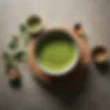 A vibrant bowl of matcha powder surrounded by tea utensils