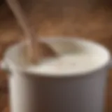 A close-up of milk simmering in a pot with a wooden spoon