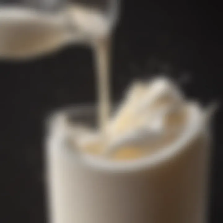 A close-up of milk being blended with foam on top in a glass